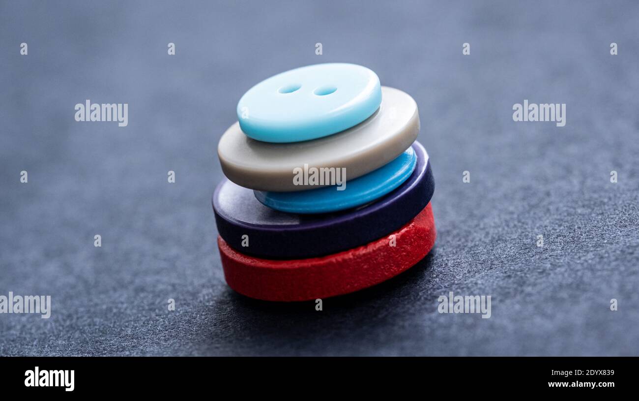 Vue rapprochée de la pile de boutons de couture colorés sur le gris arrière-plan Banque D'Images