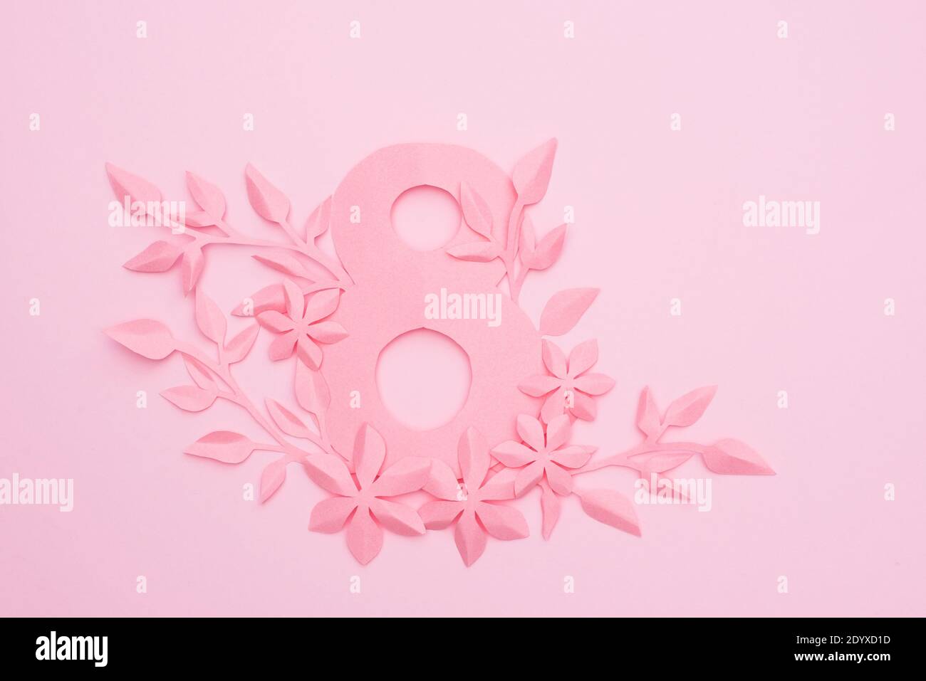 8 mars carte de la fête des femmes avec des feuilles de papier rose sur fond rose, espace de copie Banque D'Images