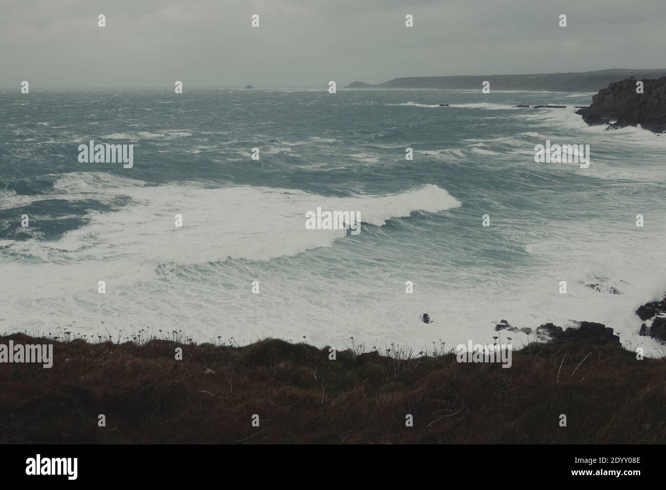 Les mers agitées et les vagues de l'océan Atlantique brisant les rochers à Lands End Cornwall, Royaume-Uni après que les vents de force de la tempête Bella gale se sont enraflés à travers le littoral Banque D'Images