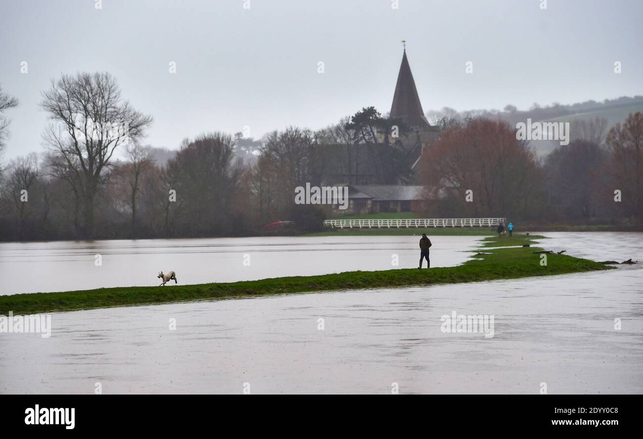 Alfriston Sussex Royaume-Uni 28 décembre 2020 - les marchettes brave le temps humide que les champs et les terres agricoles sont inondés par la rivière Cuckmere près d'Alfriston dans l'est du Sussex après la récente forte pluie et Storm Bella qui a causé des perturbations à travers le Royaume-Uni . Plus de neige et de pluie sont prévues pour le Royaume-Uni au cours des prochains jours : Credit Simon Dack / Alamy Live News Banque D'Images