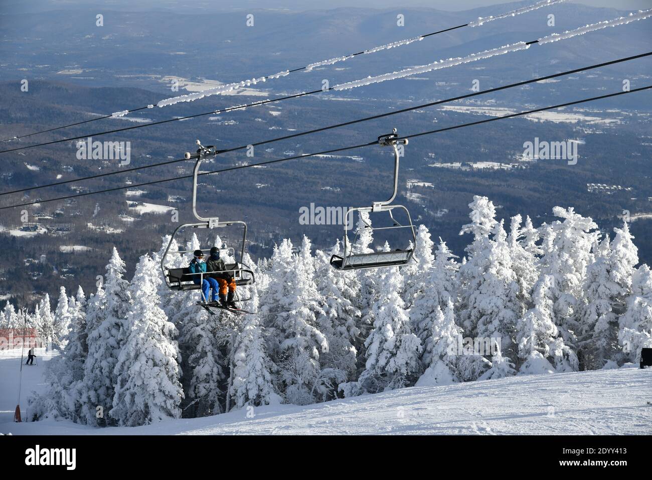 Télésiège avec des personnes à la station de ski Stowe dans le Vermont, vue  sur les pistes de montagne de Mansfield, décembre neige fraîche sur les  arbres début de saison à VT