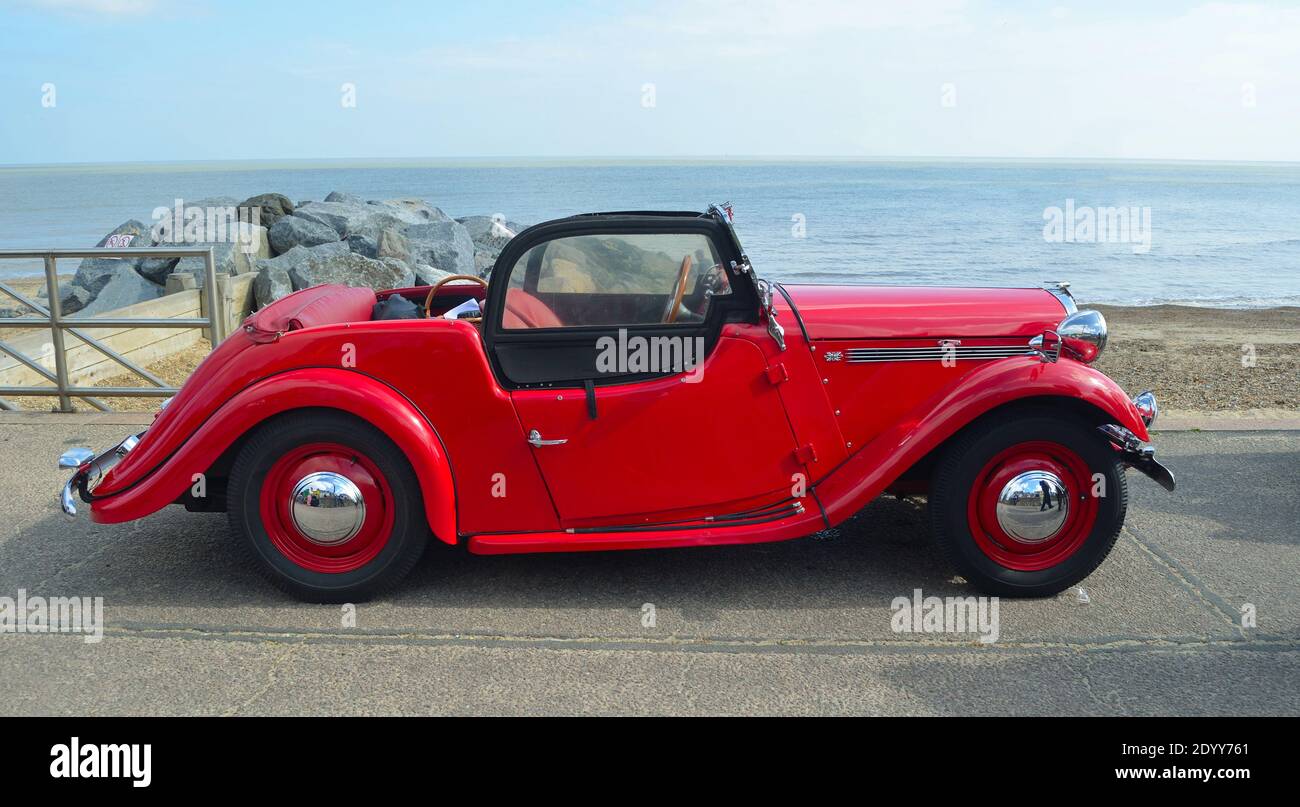 : Classique Red Singer voiture garée sur la promenade du front de mer avec la mer en arrière-plan. Banque D'Images