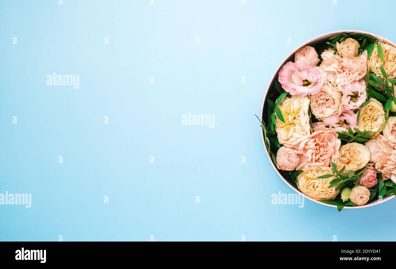 Superbes fleurs de luxe dans une boîte ronde chapeau sur fond bleu avec espace de copie. Cadeau ou cadeau le jour de la Saint-Valentin, 8 mars, fête des mères Banque D'Images