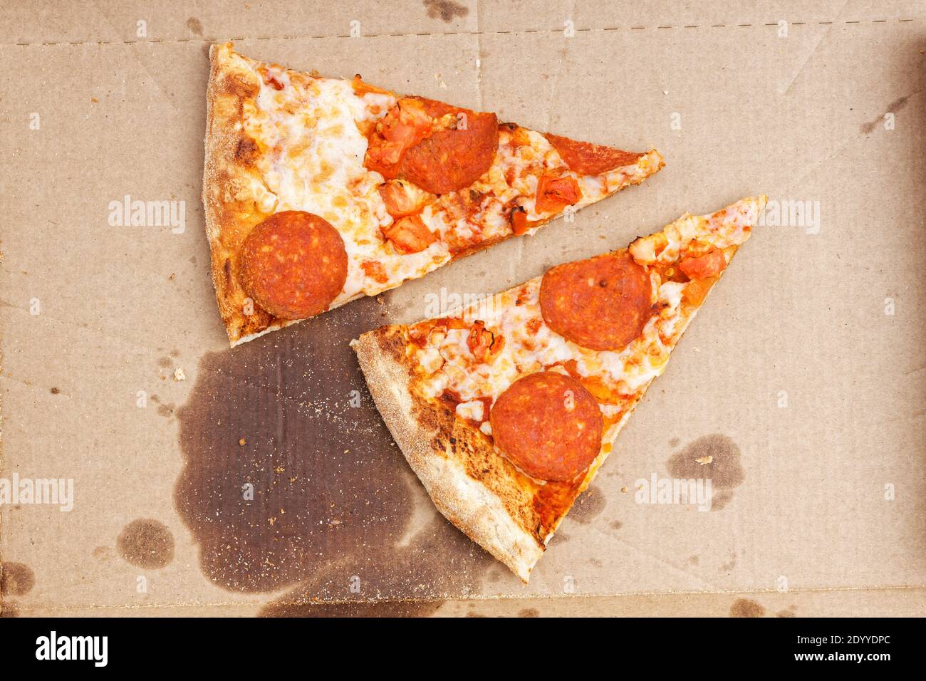 Fermer les restes de deux pizzas avec du pepperoni et des tomates dans une boîte en carton. Vue de dessus. Banque D'Images