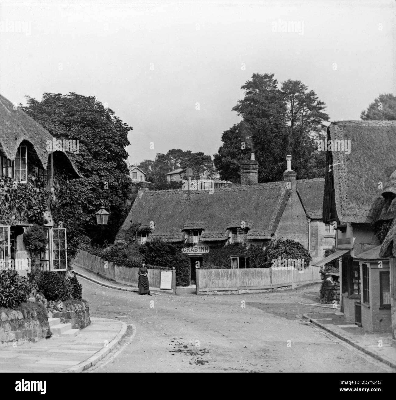 Une photographie noir et blanc de la fin de l'époque victorienne montrant le Crab Inn à Shanklin de l'île de Wight, UNE jeune femme en robe victorienne se tient à l'extérieur. Banque D'Images