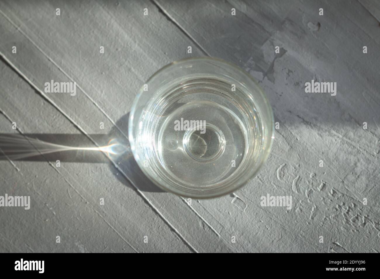 verre d'eau sur fond gris avec lumière abstraite et ombres Banque D'Images