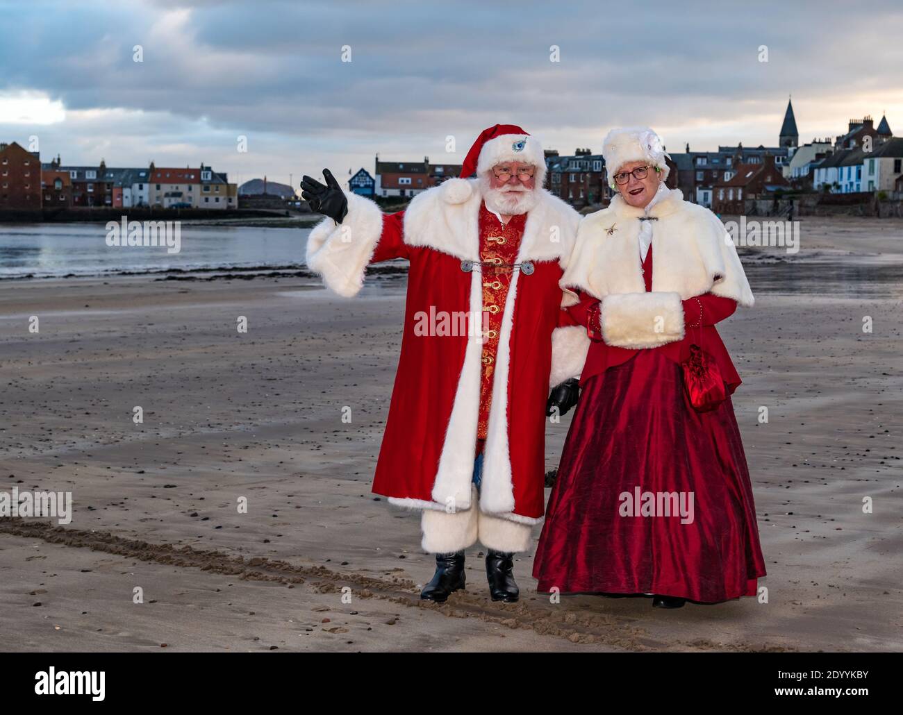 Couple vêtu de Santa ou Père Noël et costumes de Mme Claus sur la plage, Berwick Nord, Lothian est, Écosse, Royaume-Uni Banque D'Images