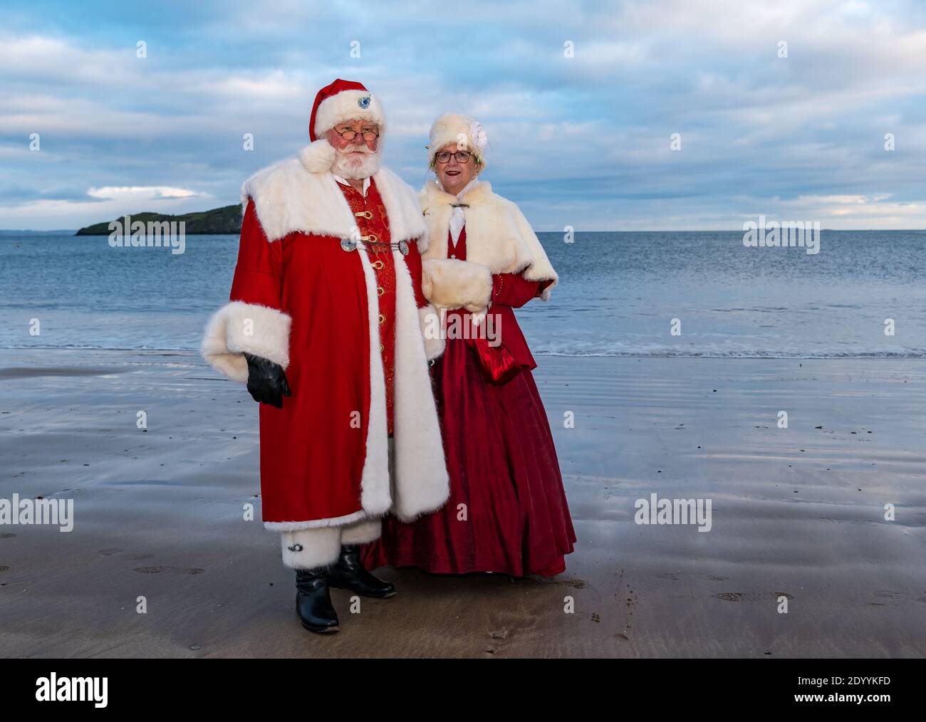 Couple vêtu de Santa ou Père Noël et costumes de Mme Claus sur la plage, Berwick Nord, Lothian est, Écosse, Royaume-Uni Banque D'Images