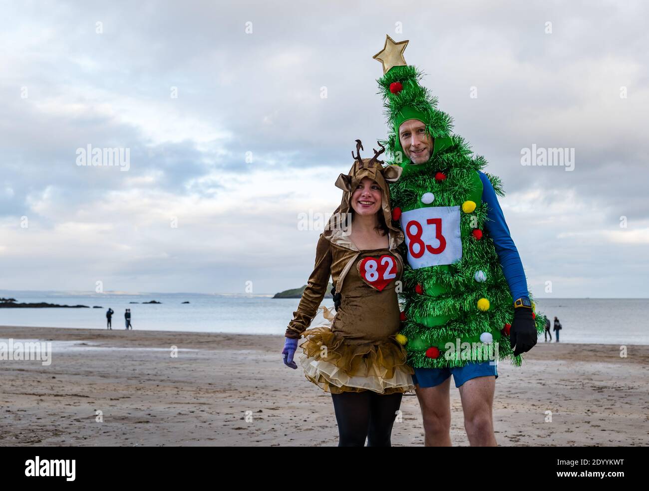 Couple dans des costumes de Noël originaux dans une course de charité sur la plage, North Berwick, East Lothian, Écosse, Royaume-Uni Banque D'Images