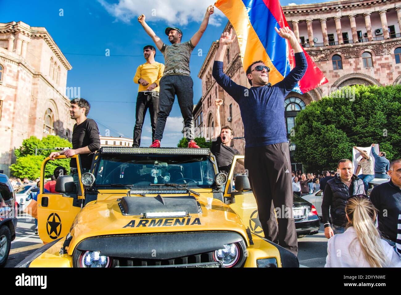 Arménie, Erevan, 23 avril 2018 - Groupe de gars debout sur une grande voiture jaune avec drapeau arménien pendant la Révolution de velours Banque D'Images