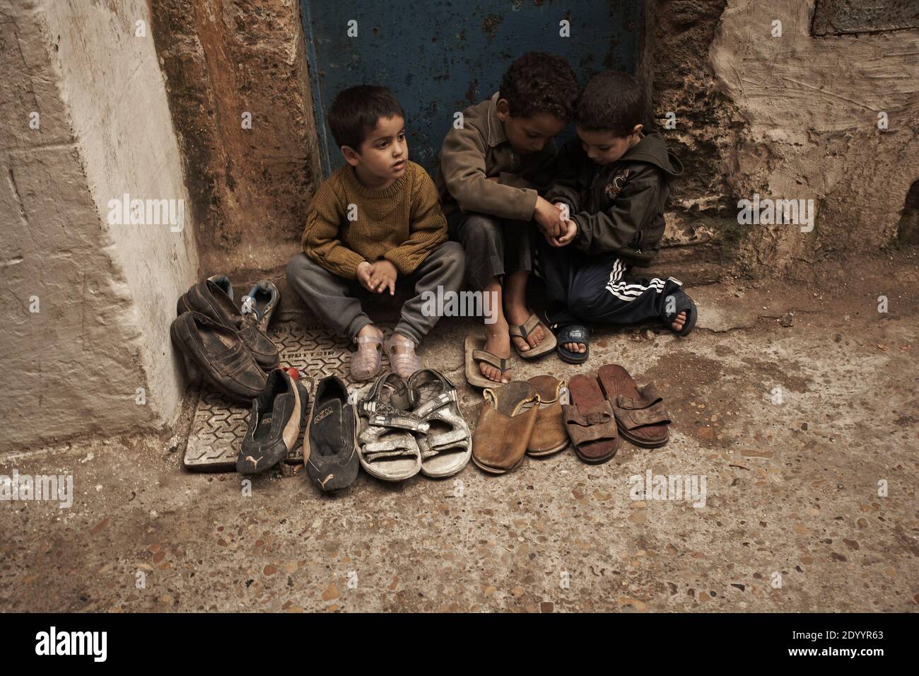 MAROC /Essaouira travail des enfants, /enfants vendant des vieilles chaussures dans la Médina ,Vieille ville . Banque D'Images