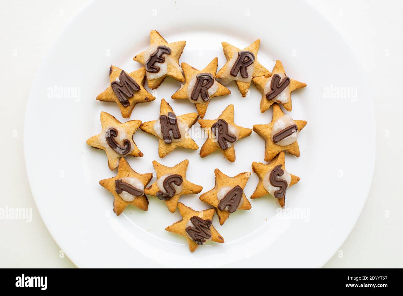 Joyeux Noël, biscuits aux étoiles de pain d'épice avec chocolat et glaçage plaque blanche Banque D'Images