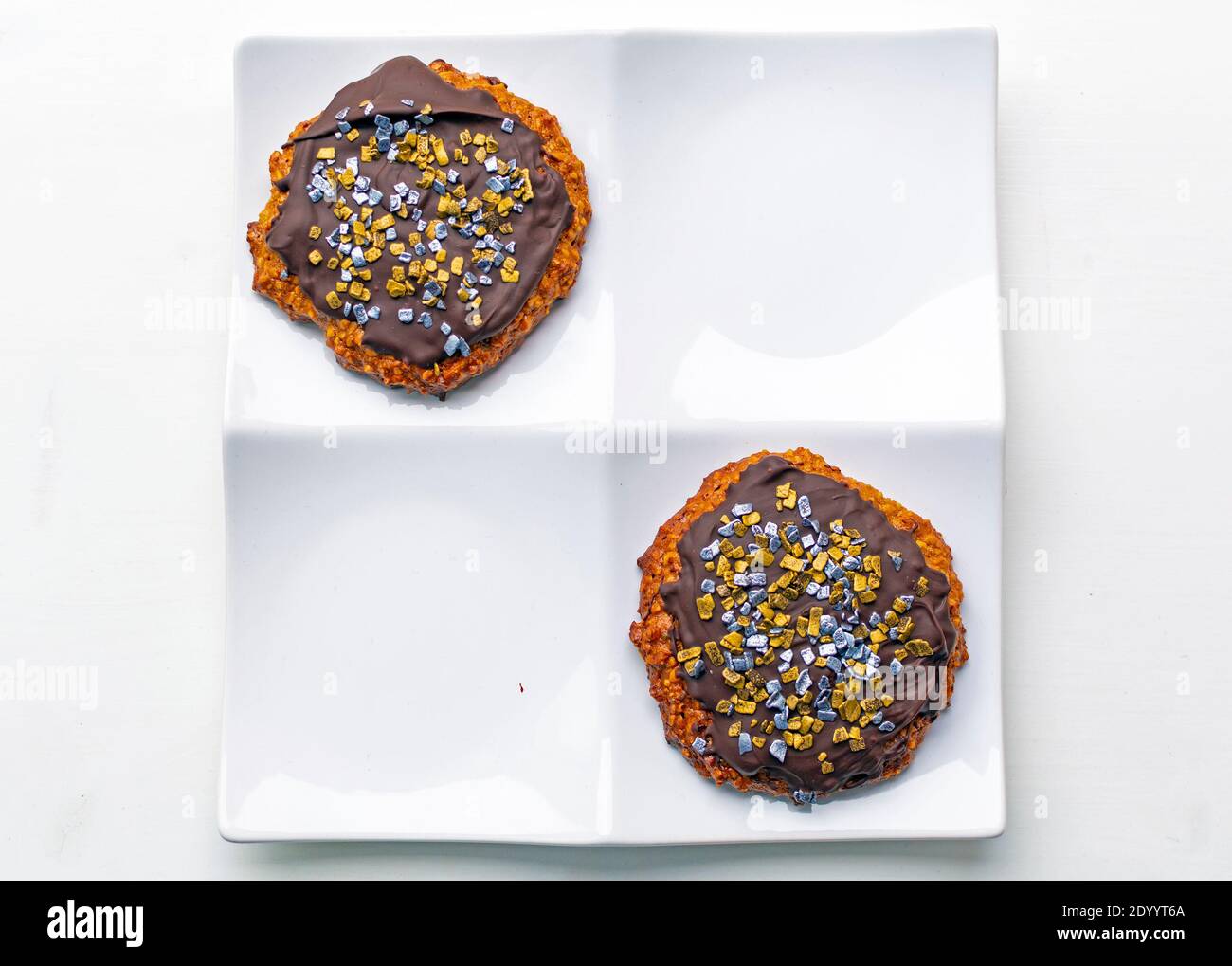 Biscuits ronds de pain d'épice avec chocolat et décorations sur carré blanc plaque Banque D'Images