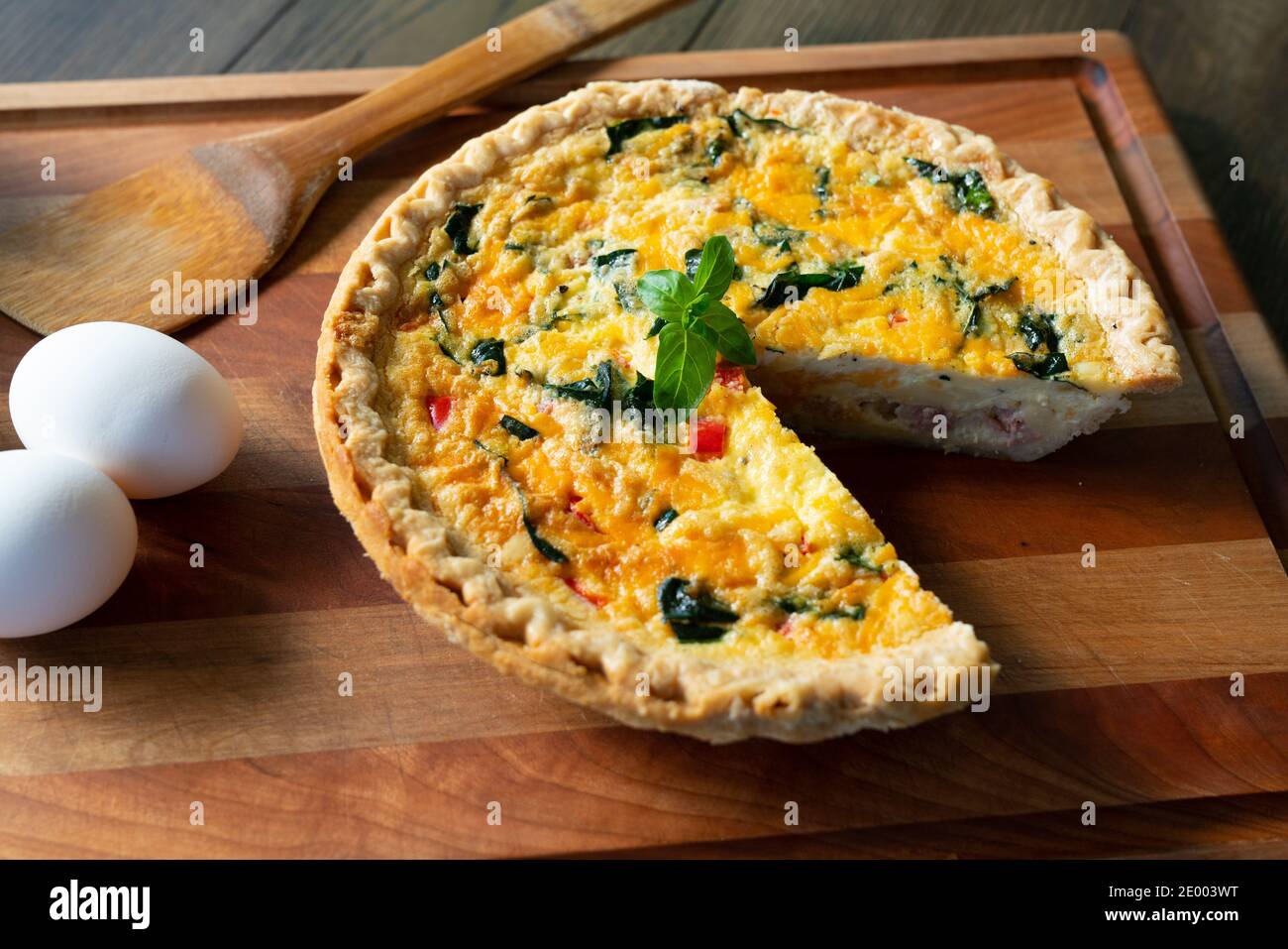Quiche lorraine fraîchement coupée en tranches sur la planche à découper Banque D'Images
