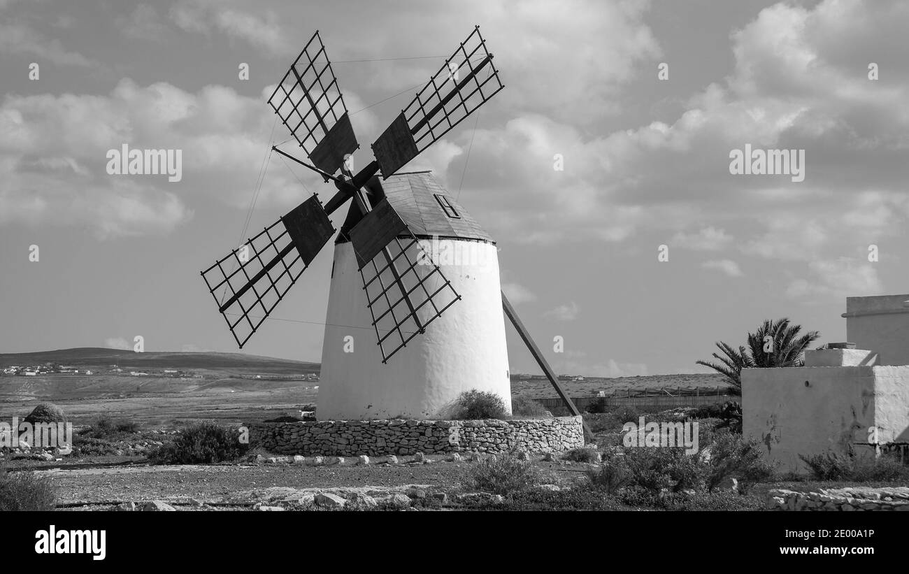 Paysage sauvage de Fuerteventura avec moulin à vent blanc, ville de Llanos de la Concepción. Énergie du vent. Îles Canaries. Espagne. Photographie en noir et blanc. Banque D'Images Paysage sauvage de Fuerteventura avec moulin à vent blanc, ville de Llanos de la Concepción. Énergie du vent. Îles Canaries. Espagne. Photographie en noir et blanc. Banque D'Images