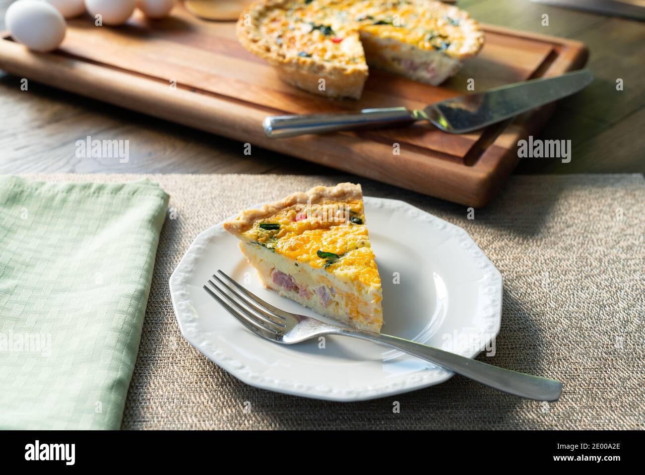 Tranche fraîche de quiche lorraine sur une assiette blanche Banque D'Images