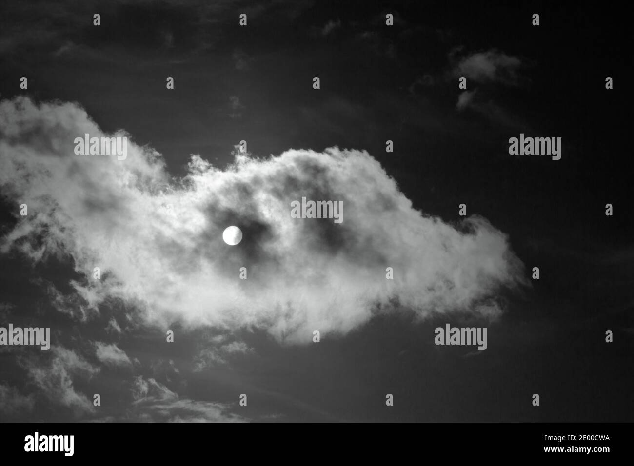 Soleil masqué par un nuage passant.Image mono Banque D'Images