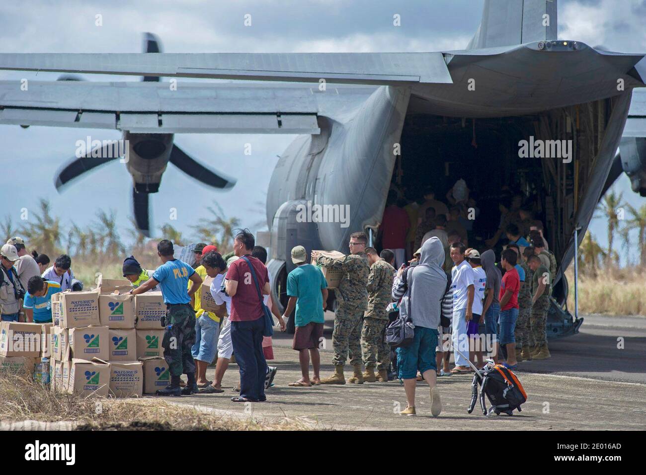 Guiuan, province de l'est du Samar, République des Philippines (nov 16, 2013) des marins du porte-avions déployé par l'avant de la Marine américaine USS George Washington (CVN 73), aux côtés de Marines et de civils philippins, aident à décharger des approvisionnements d'un Hercules HC-130 de l'Escadron de soutien de l'escadre maritime (SMSS) 172 à l'appui de l'opération Damayan. Le groupe de grève George Washington appuie la 3e Brigade expéditionnaire maritime pour aider le gouvernement philippin à répondre aux séquelles du Super Typhon Haiyan en République des Philippines. Photo par US Navy via ABACAPRESS.COM Banque D'Images