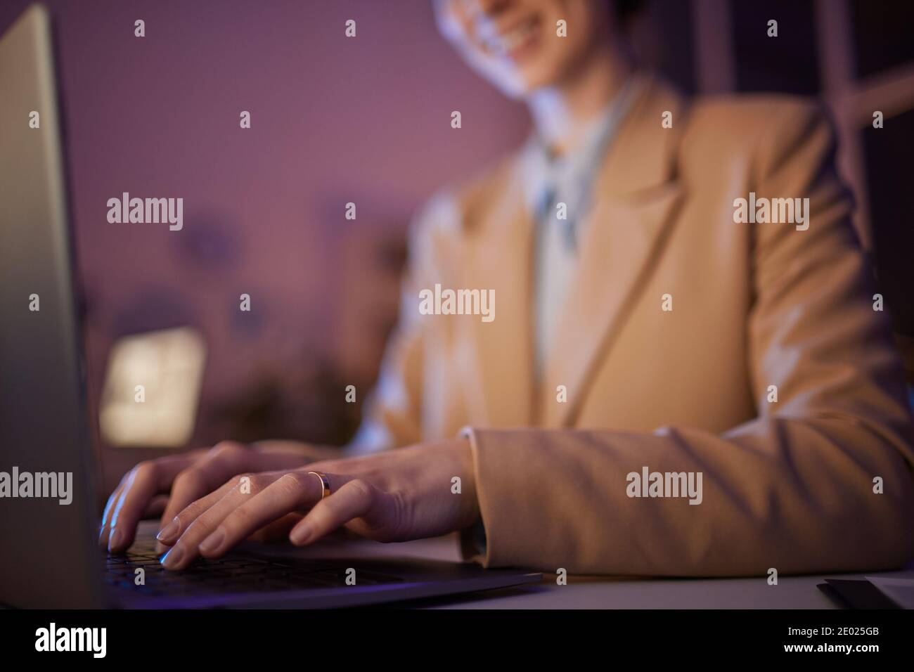 Jeune femme méconnaissable en tenue de cérémonie passant la soirée au bureau sur le plan d'affaires avec ordinateur portable Banque D'Images