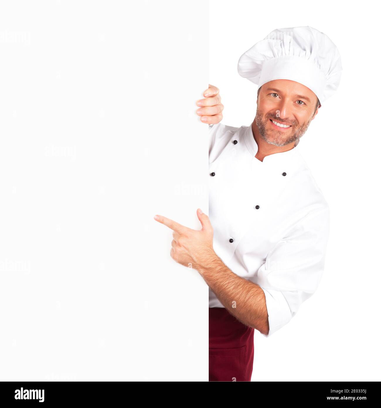 Chef souriant pointant vers un panneau vierge Banque D'Images