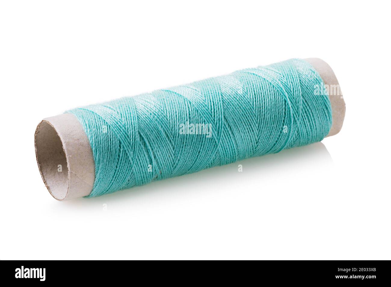 Bobine de fil de couleur émeraude isolée sur fond blanc. Banque D'Images