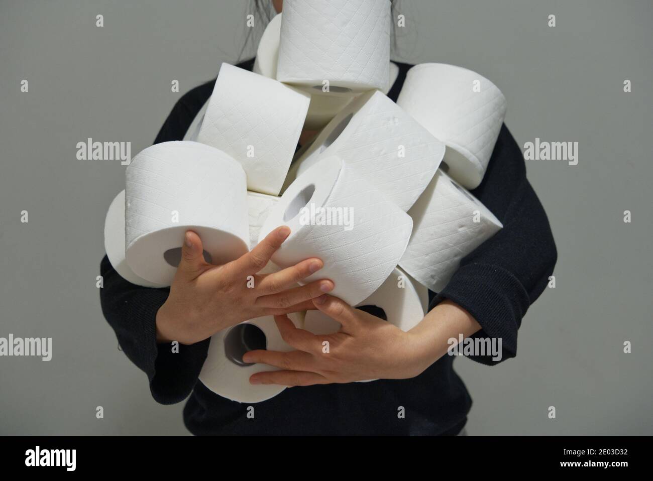 Femme asiatique portant plusieurs rouleaux de papier toilette, papier crise concept, stockage de papier toilette Banque D'Images