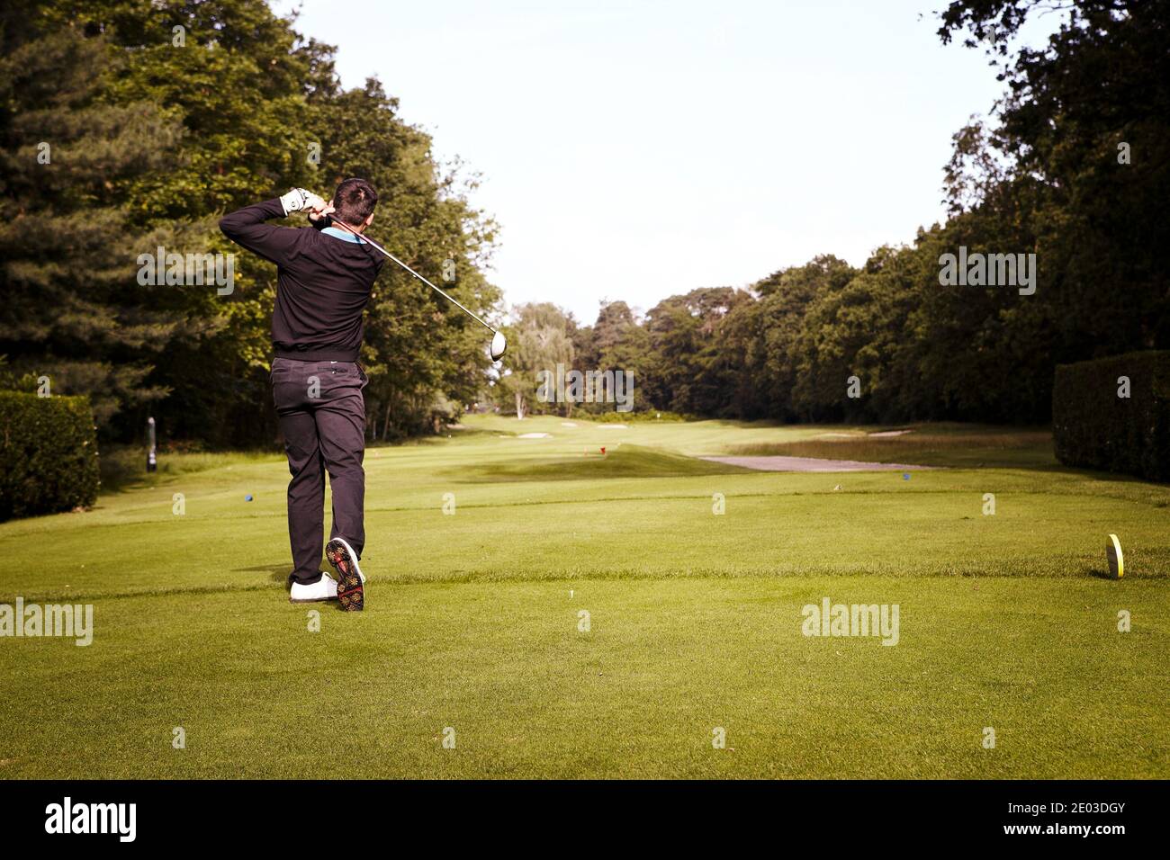 Golfeur frappe avec le club dans l'air. Vue arrière. Retour tourné. Banque D'Images