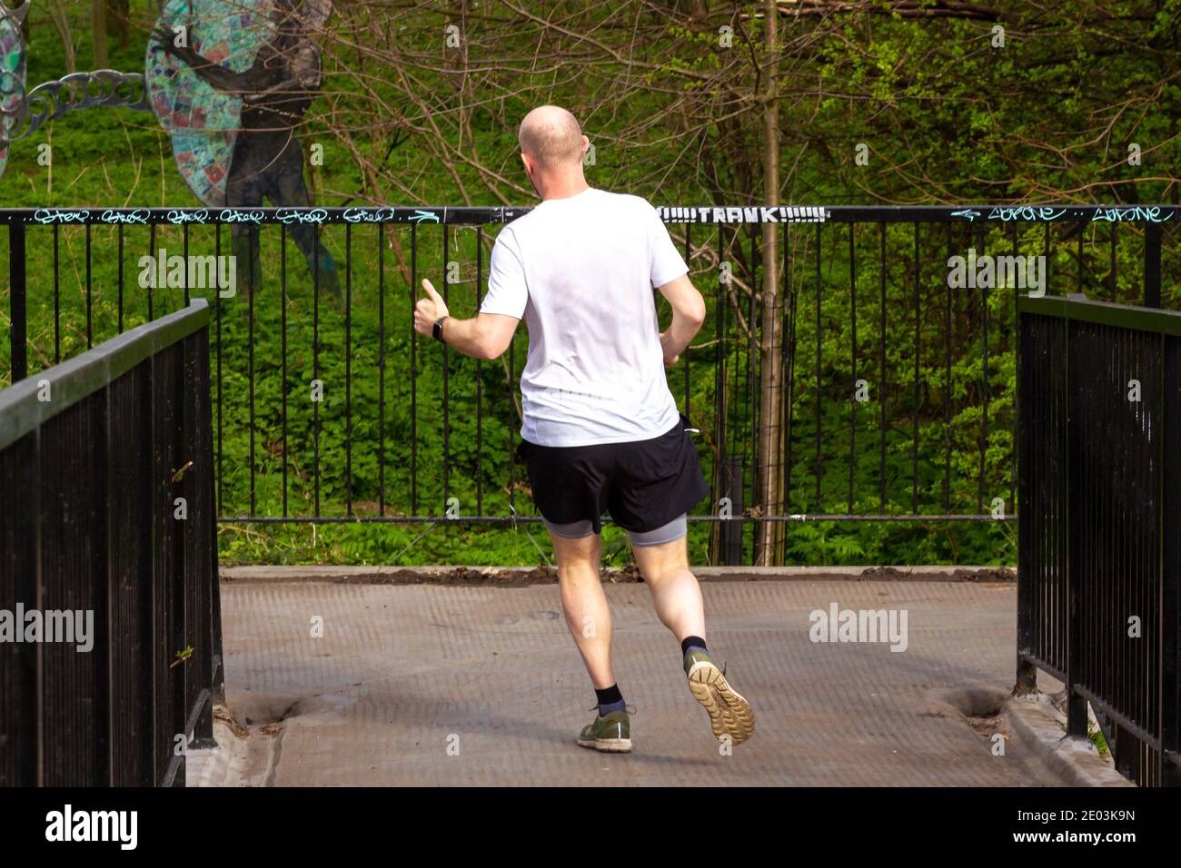 Un jogger traverse un pont à Hackney et donne le signe du pouce vers le haut Banque D'Images