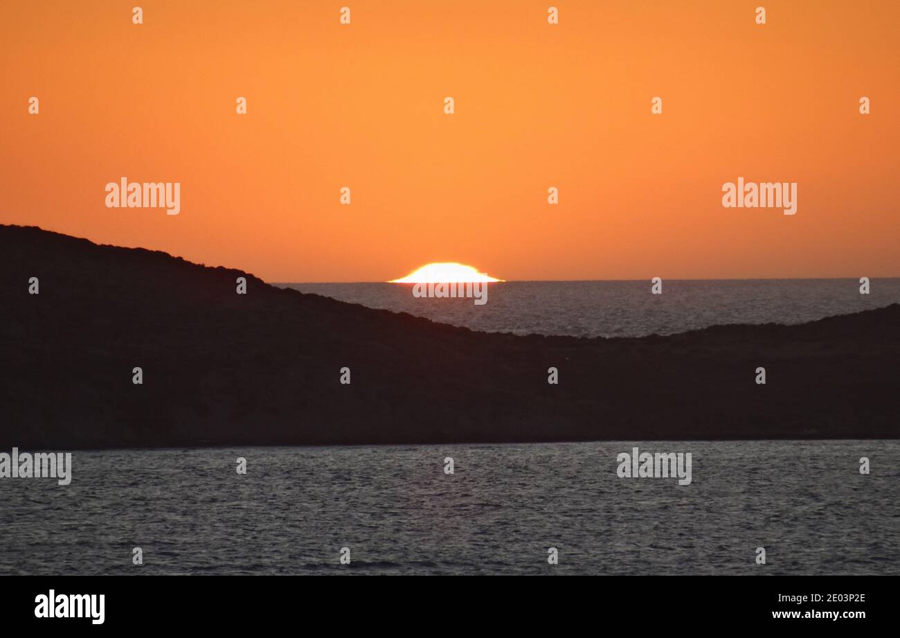 Coucher de soleil sur la plage de Plati , Myrina, l'île de Lemnos dans les îles grecques avec vue sur Ormos Vatopediou , la montagne Athos en arrière-plan Banque D'Images