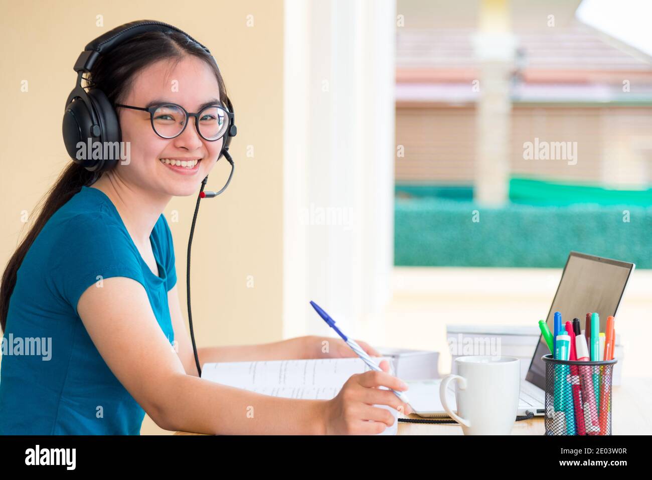 Jeune fille asiatique adolescente étudiante avec des lunettes de casque est à la recherche tout en utilisant un ordinateur portable étude en ligne à distance de l'école apprentissage de l'éducation f Banque D'Images