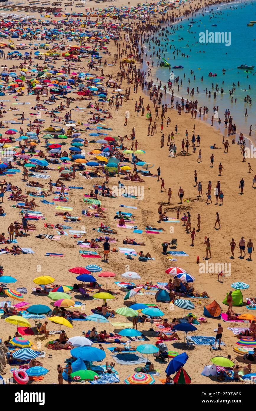 Vue depuis le dessus d'une plage pleine de personnes avec Nombreuses couleurs en Algarve Portugal Banque D'Images