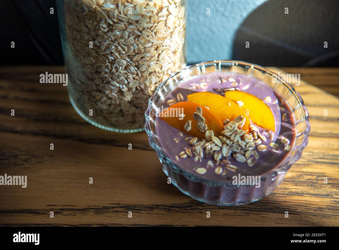 Açai smoothie, granola, graines, fruits frais dans un bol en verre sur une table en bois. Manger un bol de petit déjeuner sain. Vue de dessus. Photo de haute qualité Banque D'Images