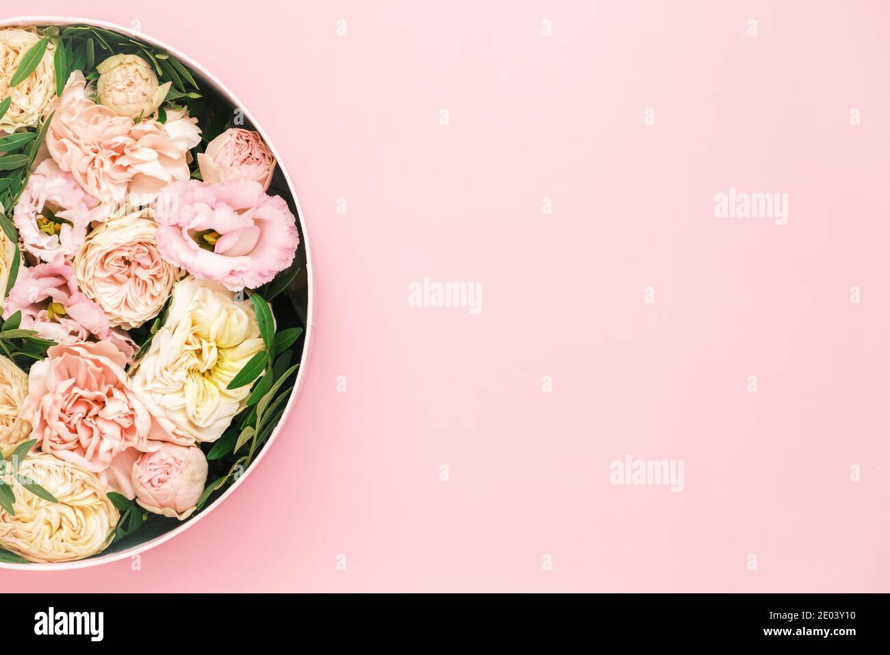 Luxe belles fleurs dans un chapeau rond boîte sur le fond rose avec espace de copie. Cadeau ou cadeau le jour de la Saint-Valentin, 8 mars, fête des mères Banque D'Images
