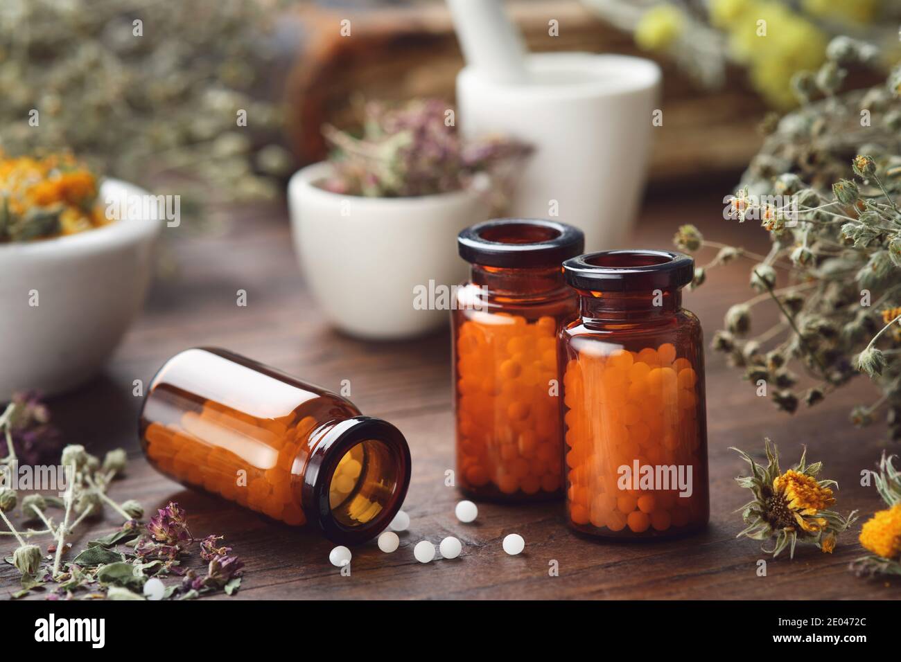 Trois bouteilles de globules homéopathiques et d'herbes médicinales. Concept de médecine d'homéopathie. Banque D'Images