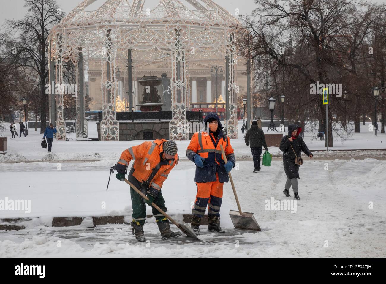 Moscou, Russie. 25 décembre 2020 un employé d'un service municipal portant des masques est engagé dans le nettoyage de la neige tombée sur la place de la Révolution dans le centre de Moscou à la Saint-Sylvestre, en Russie Banque D'Images