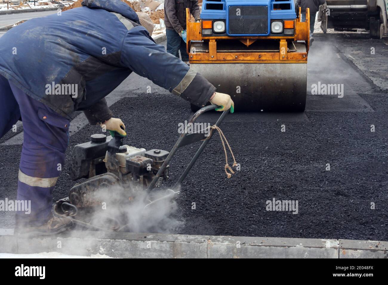 Développement des infrastructures urbaines. Rouleau de route en asphalte avec compacteur à rouleaux à vibrations lourdes presser l'asphalte chaud neuf. Nouvelle construction de routes. Route asphaltée Banque D'Images