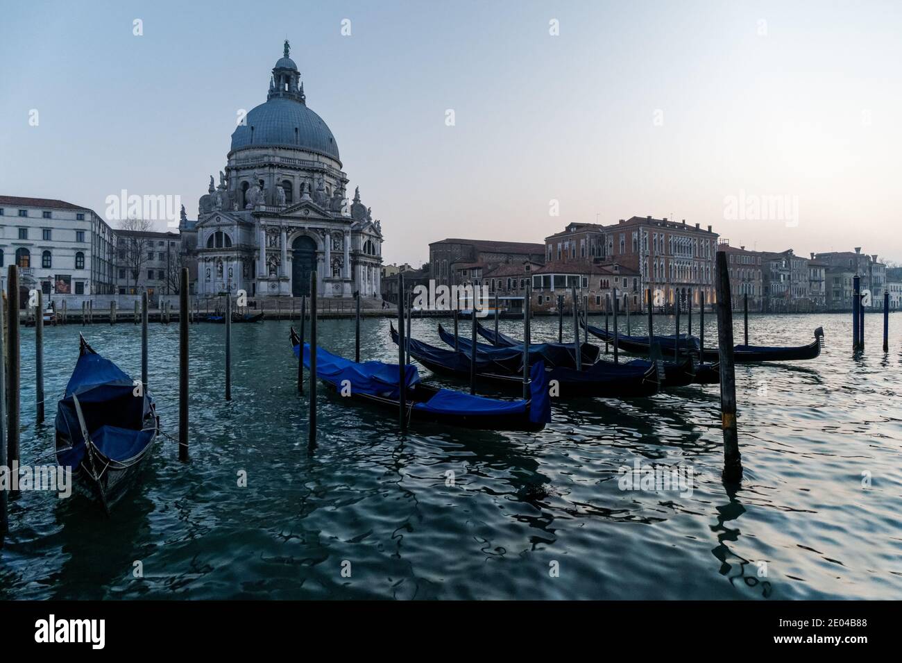 Gondole vénitienne au coucher du soleil, gondoles amarrées à Venise avec la basilique Santa Maria della Salute en arrière-plan, en Italie Banque D'Images