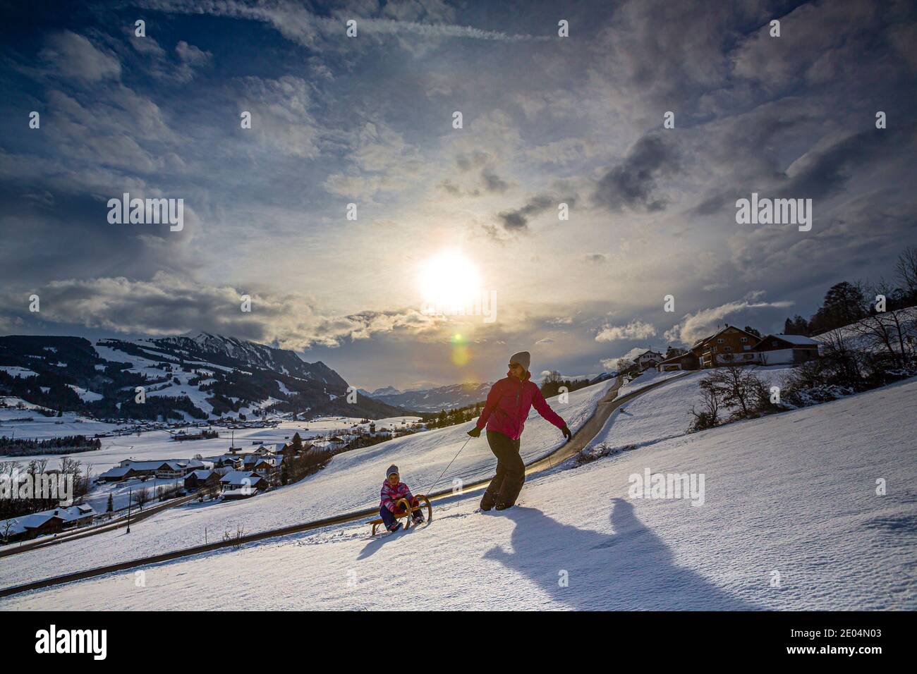 Allemagne, Bavière, Allgäu, femme et fille profitant d'une journée d'hiver en traîneau Banque D'Images