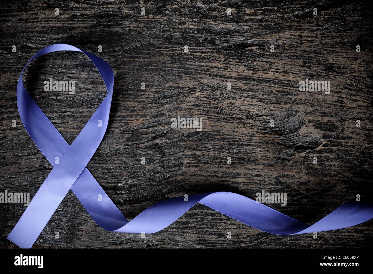 Vue de dessus du ruban bleu periwinkle sur fond de bois avec espace de copie. Sensibilisation au cancer de l'estomac et de l'œsophage, troubles de l'alimentation et pulmonaire. Banque D'Images