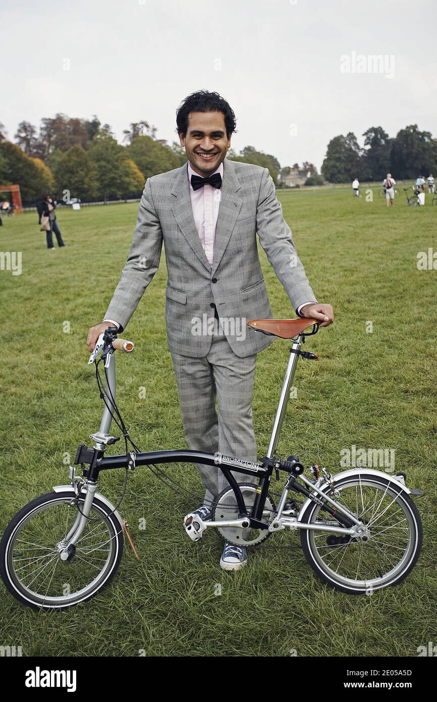 Participant mâle avec costume et noeud papillon posant avec la bicyclette pliante Brompton aux Championnats du monde Brompton, tenu au Palais de Blenheim, Royaume-Uni . Banque D'Images