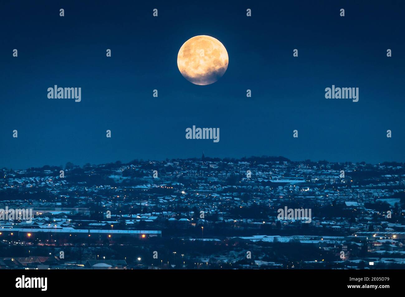 Halesowen, West Midlands, Royaume-Uni. 30 décembre 2020. La dernière pleine lune de 2020 est jaune éclatant alors qu'elle se couche sur les lumières de la ville du pays noir dans les Midlands de l'Ouest. La pleine lune de décembre est parfois appelée la « lune froide ». Le surnom vient de la tribu américaine des Mohawks des Premières nations et fait référence aux températures froides de décembre qui signalent la véritable arrivée de l'hiver. Crédit : Peter Lophan/Alay Live News Banque D'Images