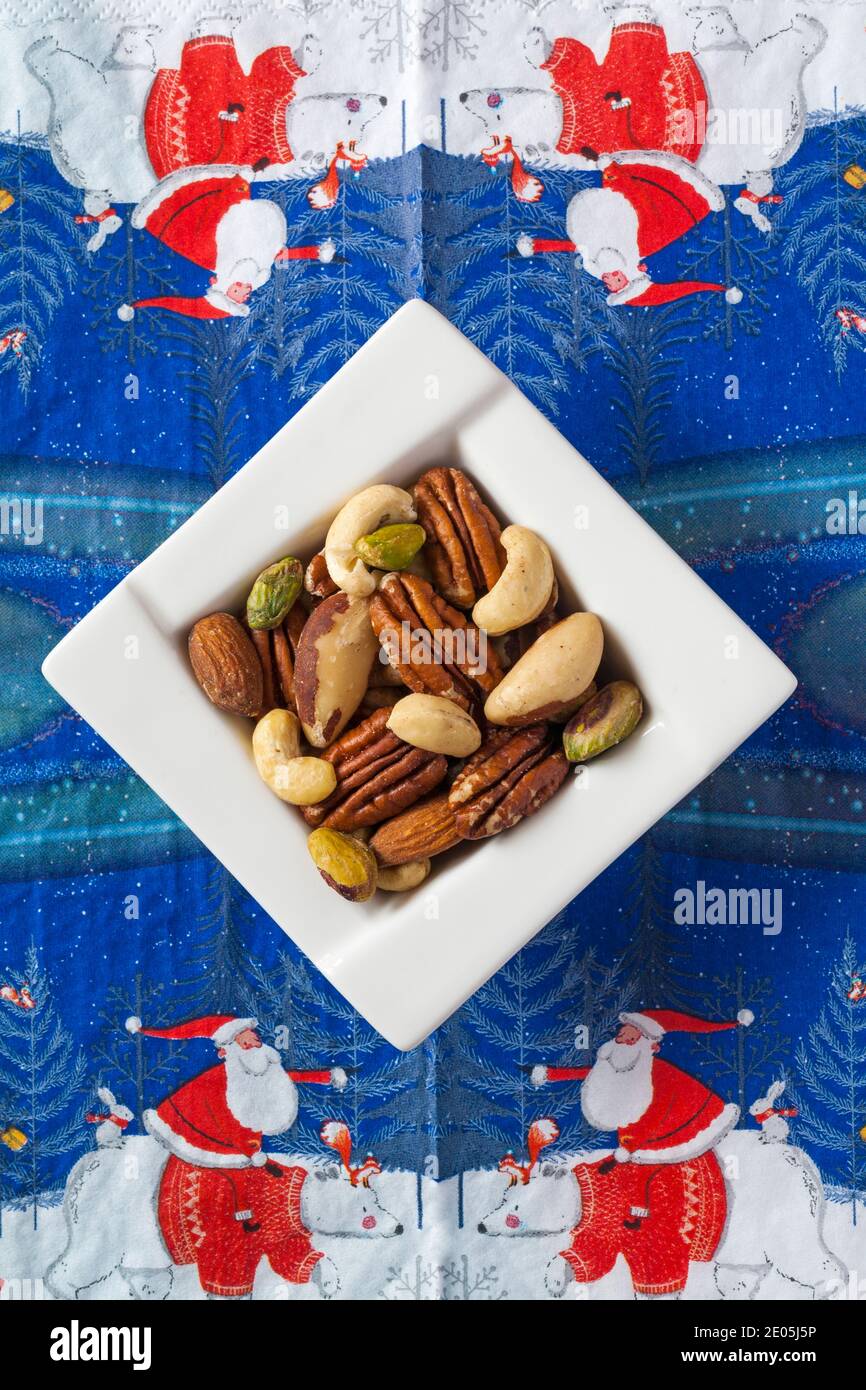Bol de noix, noix de cajou, amandes, braises, pacanes et pistaches, noix non salées sur la serviette de Noël en serviette - Noël festif Banque D'Images