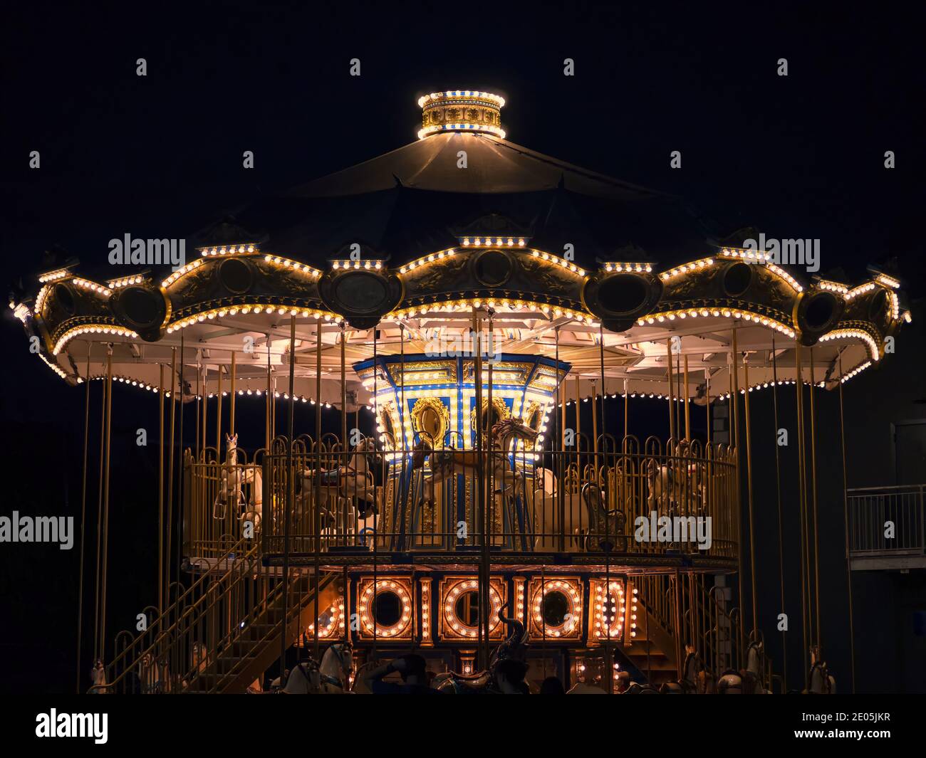 Le carrousel dans le parc d'attractions dans les lumières à nuit Banque D'Images