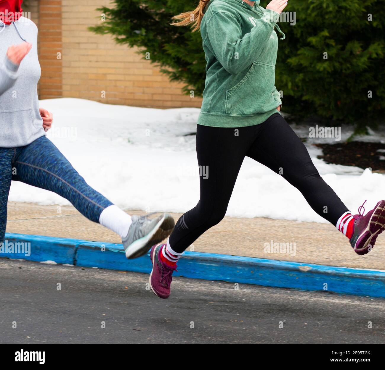 Les filles du secondaire perfroquent des exercices de course dans un parking portant des masques pendant la pandémie de 2020. Banque D'Images