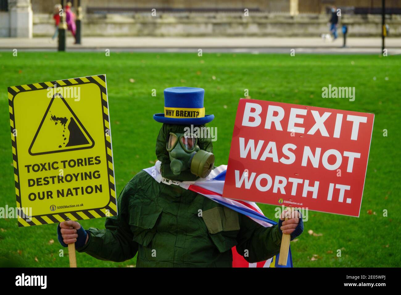 Steve Bray, M. Stop Brexit, un manifestant pro-européen, portant un masque à gaz et un costume CBRN. Il tient des écriteaux indiquant que les conservateurs sont toxiques et que le Brexit ne vaut pas la peine, alors que les députés débattent de l'Accord commercial de l'UE à la Chambre des communes après que le Parlement ait été rappelé de la suspension de Noël (30 décembre 2020). Le Parlement a voté en faveur de l'accord commercial UE-Royaume-Uni et le Royaume-Uni a quitté complètement l'UE le 1er janvier 2021. Banque D'Images