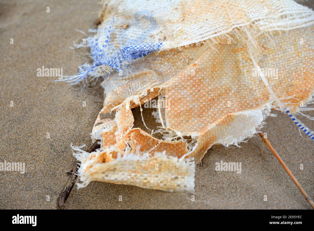 Un sac érodé qui s'est lavé sur la plage et s'enchâssés dans le sable Banque D'Images