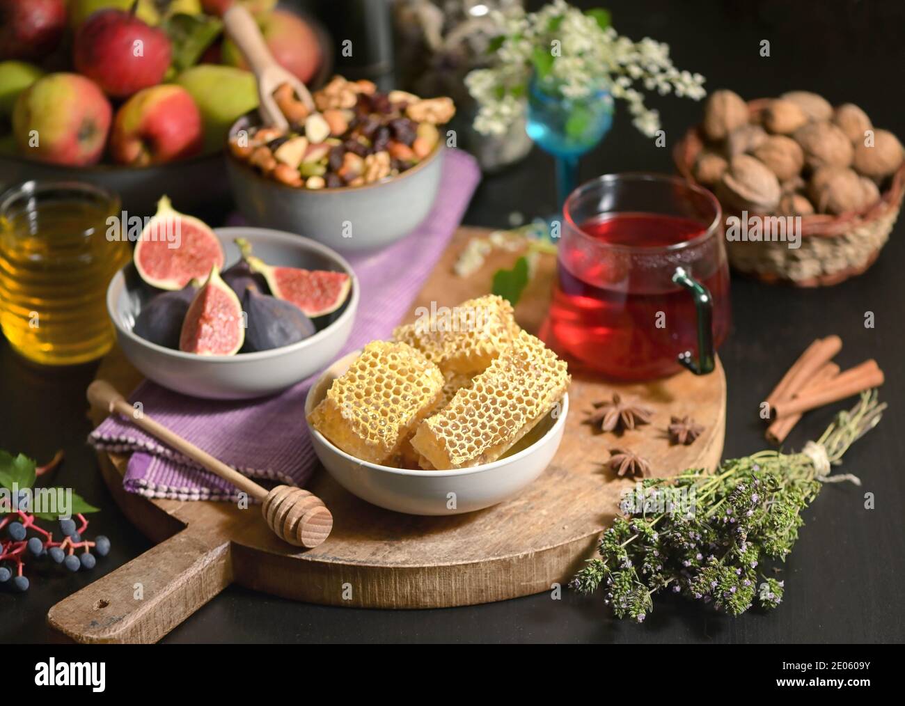 Miel, nid d'abeilles, thé, fruits secs et figues sur la table d'automne Banque D'Images
