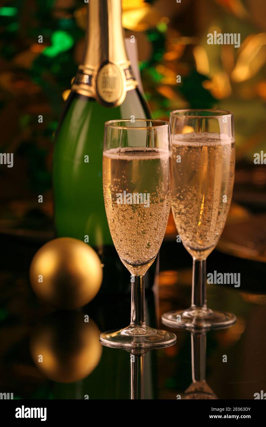 Gros plan de deux verres ou flûtes de champagne avec une bouteille et une boule de noël sur fond sombre pour saint valentin Banque D'Images