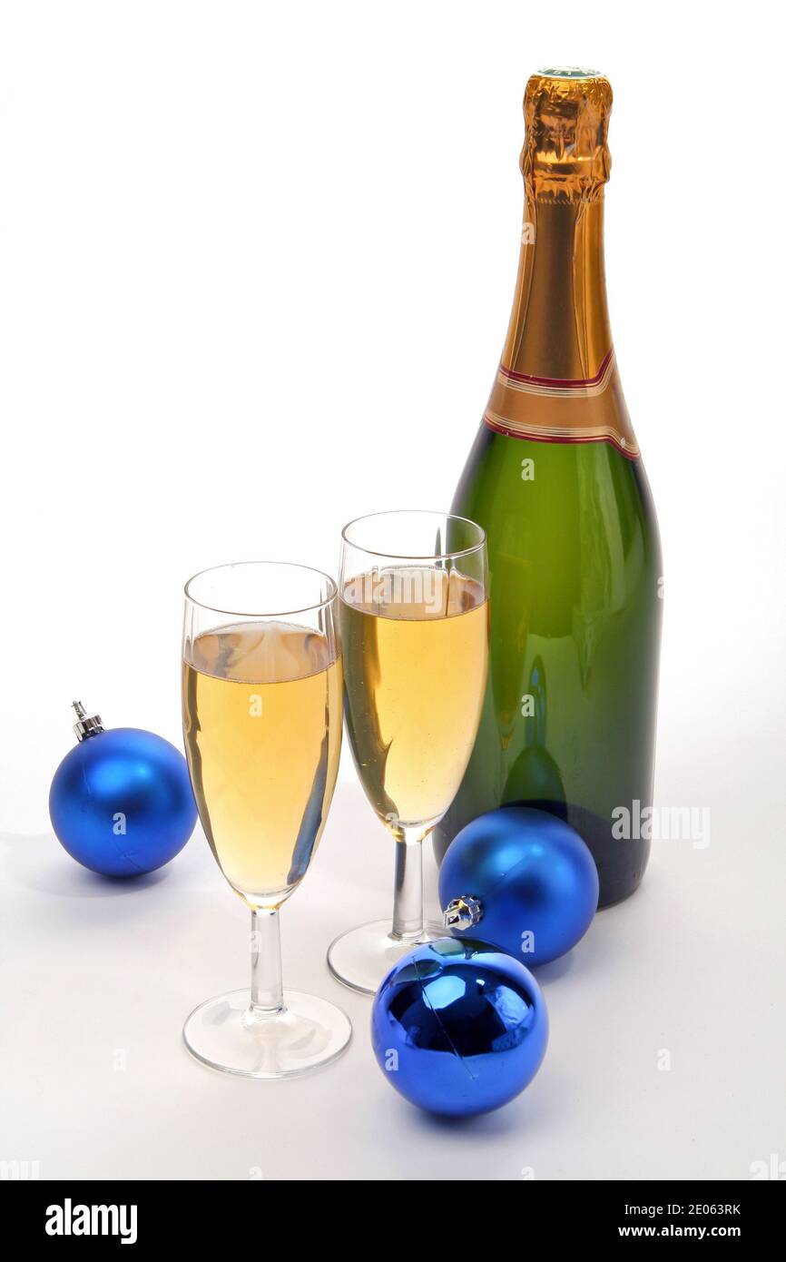 Bouteille avec deux verres de champagne et des boules de Noël isolées sur fond blanc Banque D'Images