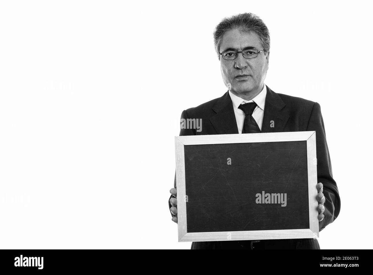 Studio shot of Persian senior businessman holding blank blackboard Banque D'Images